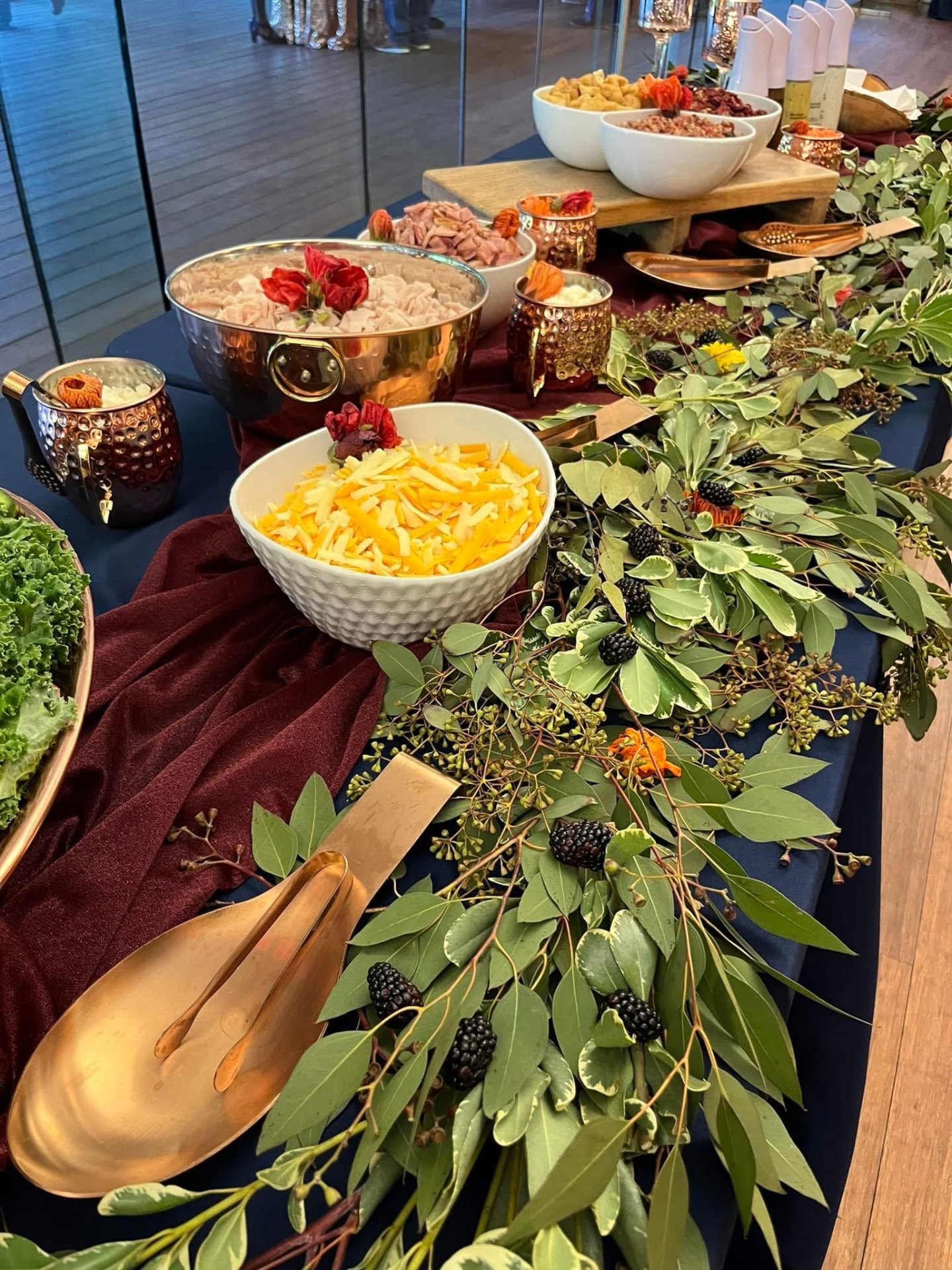 Copper and brass buffet with toppings, greenery and edible flowers