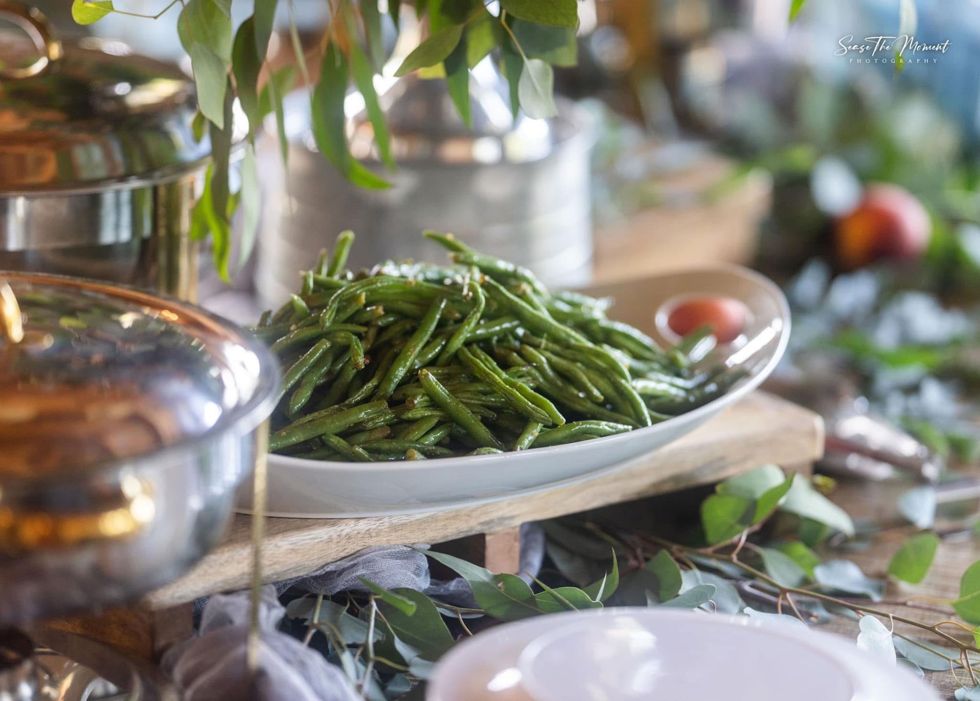 Garlicky sautéed green beans plated on a wooden riser