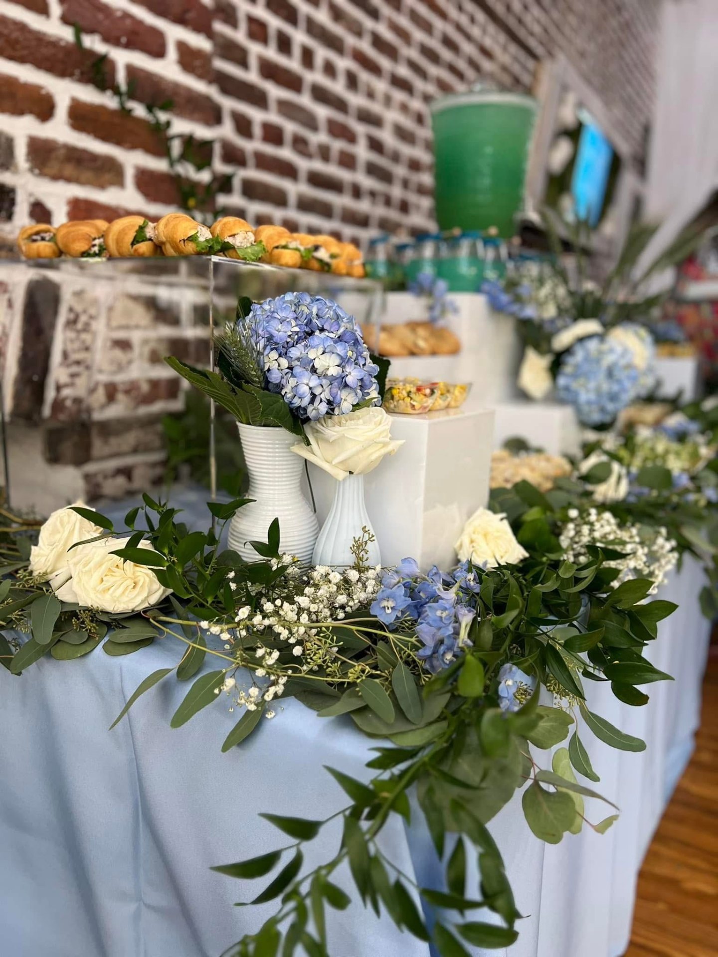 Blue and white brunch table with hydrangeas, roses and croissants