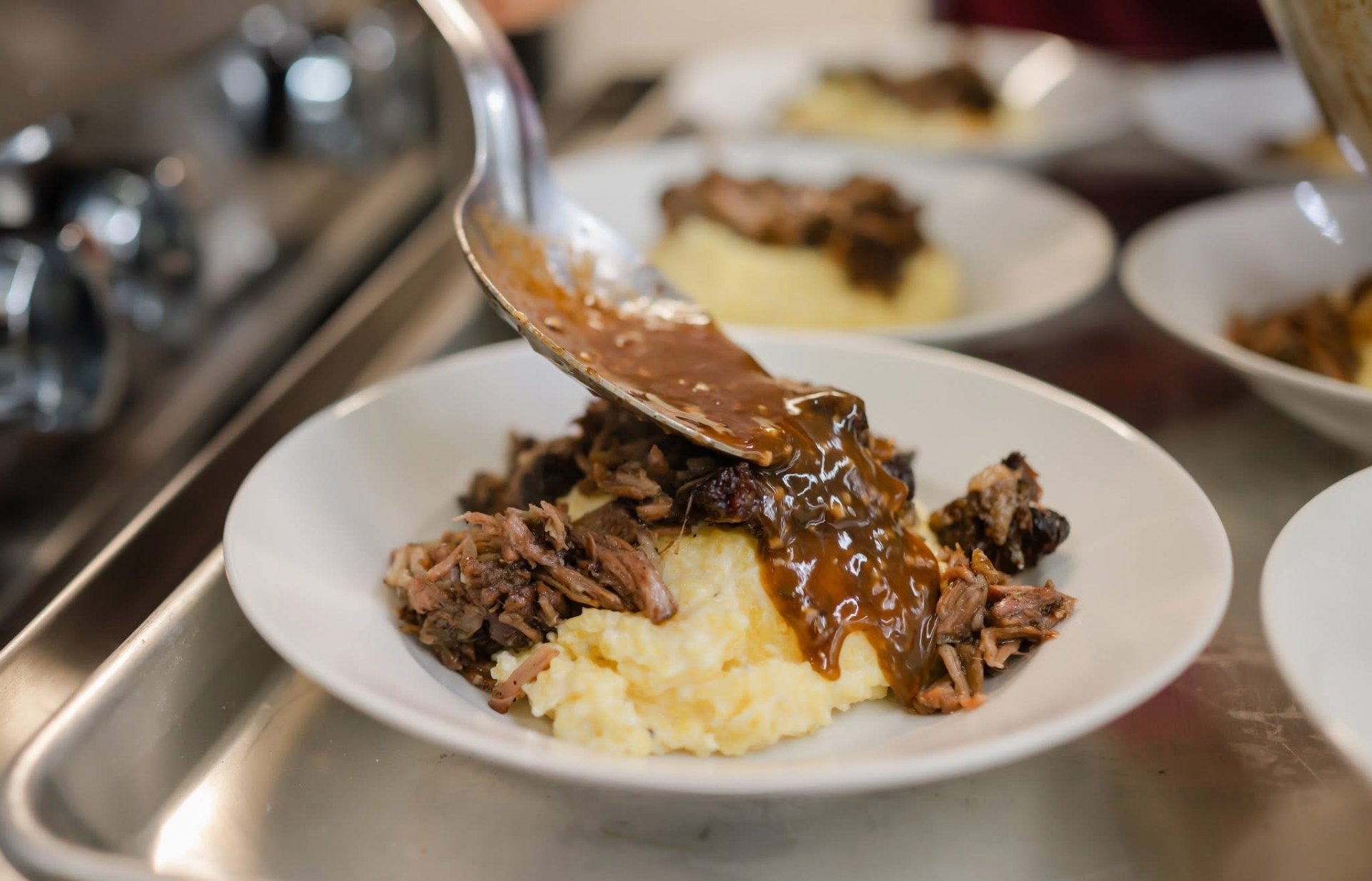Braised brisket over creamy stone-ground grits with gravy